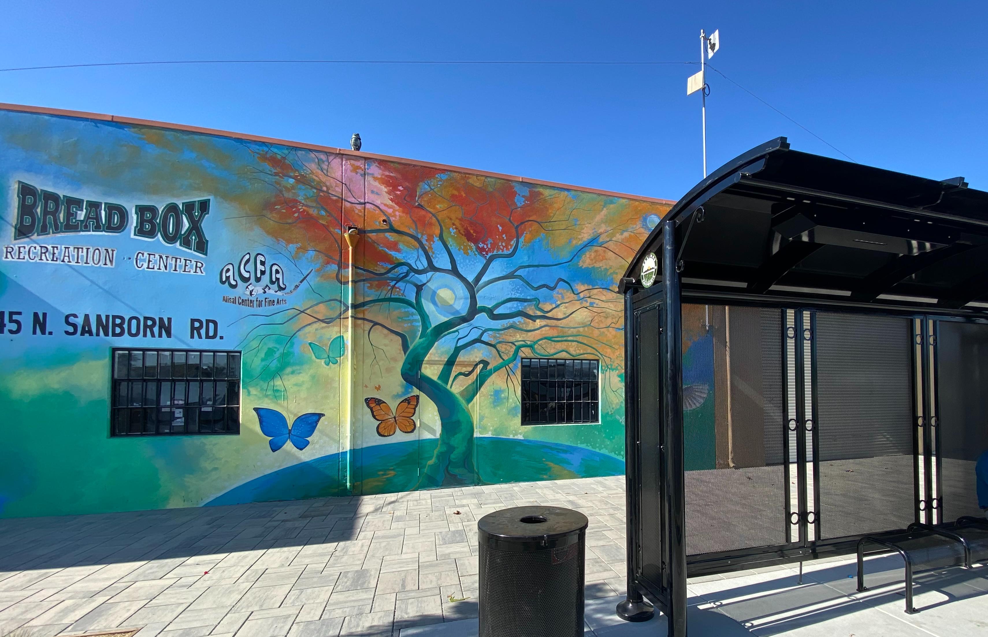 Colorful mural on the Bread Box Recreation Center at 45 N. Sanborn Road featuring a tree, butterflies, and the Alisal Center for Fine Arts logo.