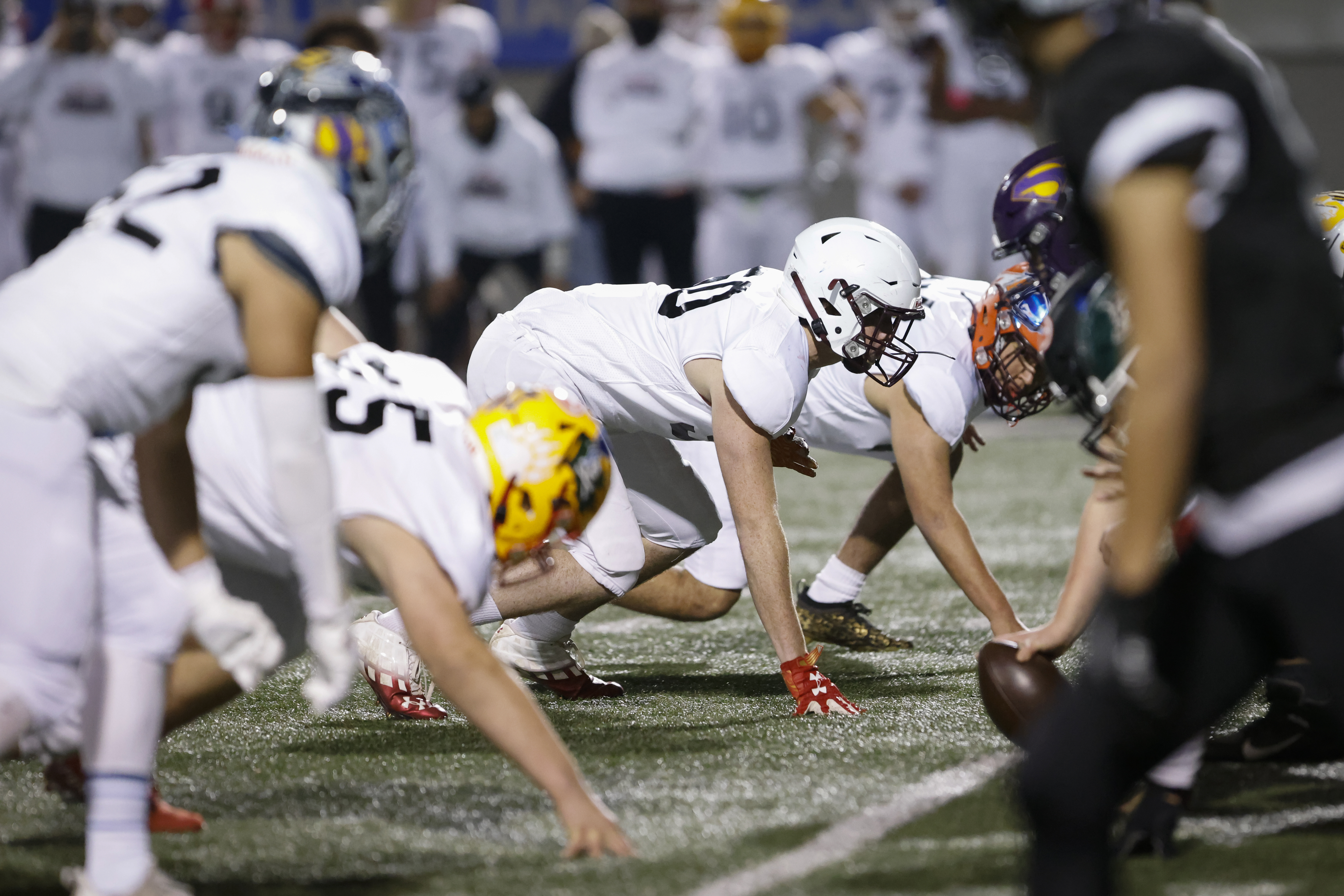 Defensive-lineman-football-players-in-whote-uniforms-in-starting-position.jpg