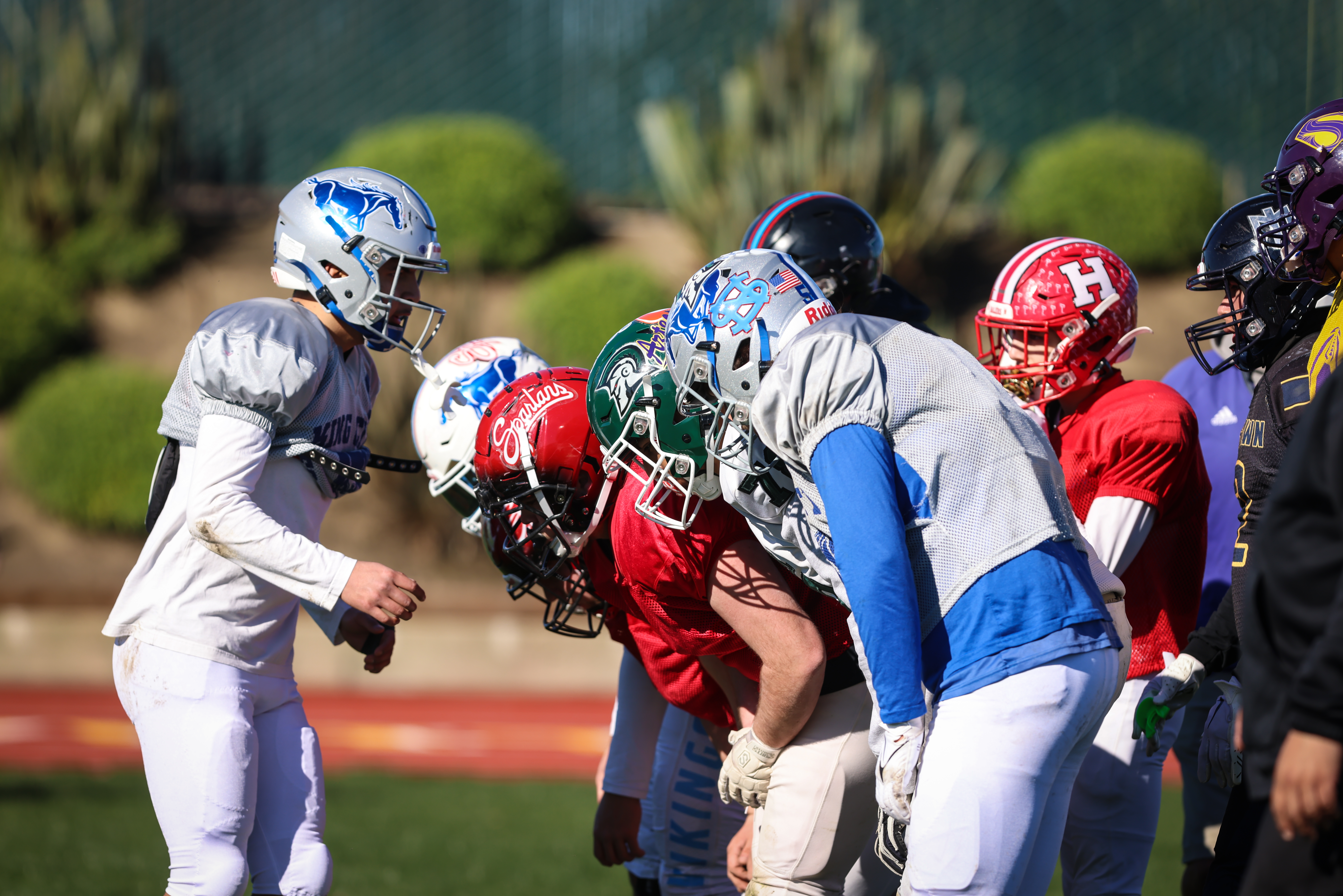 Multiple-football-playes-huddled-in-different-uniforms.jpg
