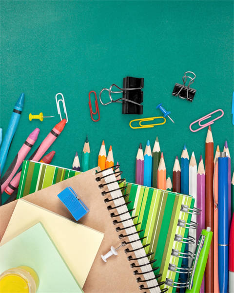 Stock Image of notebooks, crayons, color pencils, and paper clips