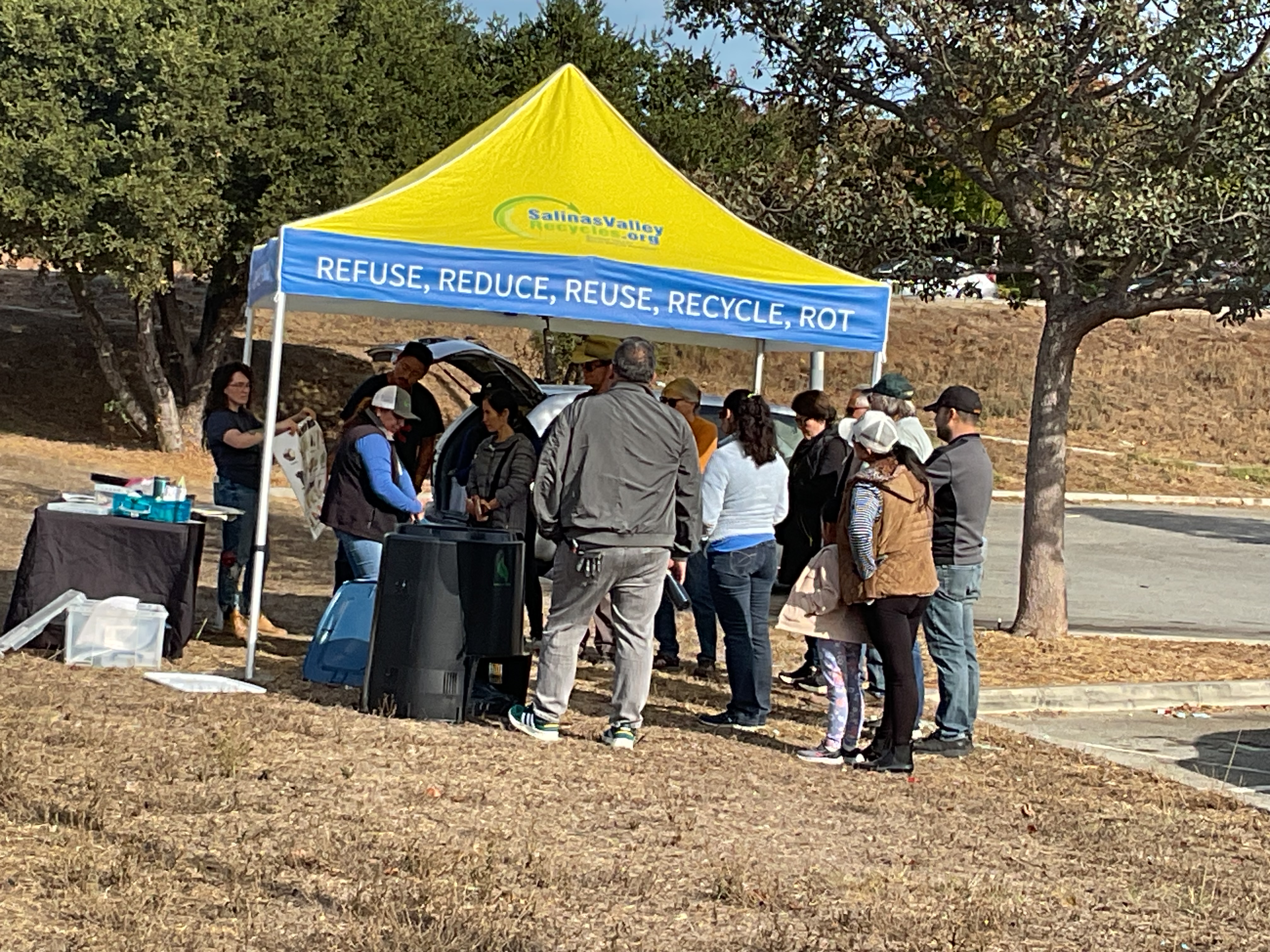 people gather under a tent to learn about composting
